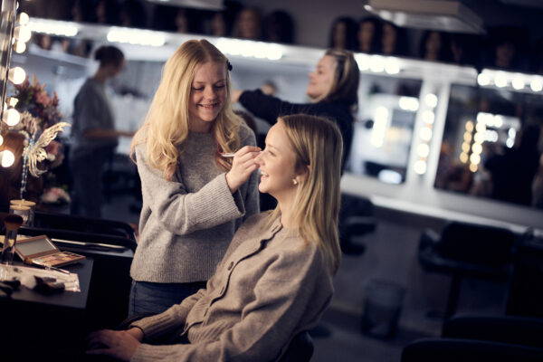 En elev som sminkar sin klasskamrat på lektionen.