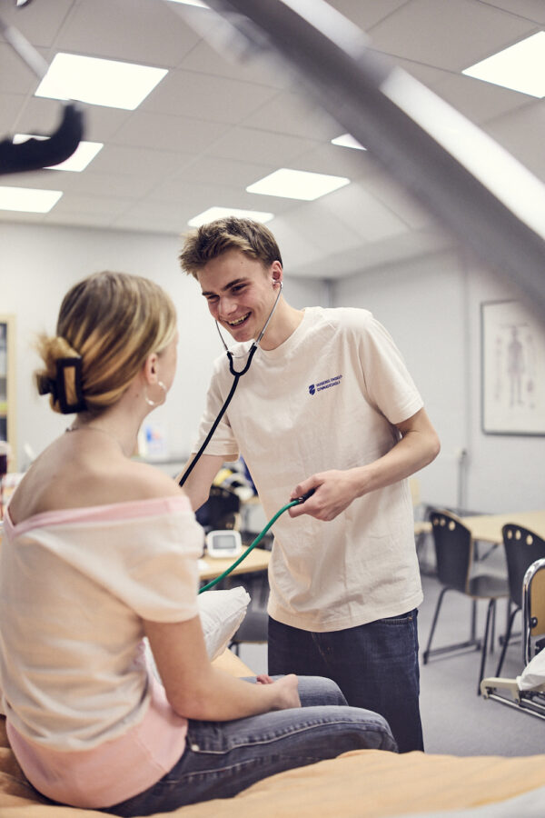 En elev tar blodtryck på sin klasskamrat på lektionen.