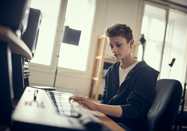 Elev spelar digitalt piano i musiksal på Varbergs Enskilda Gymnasieskola.