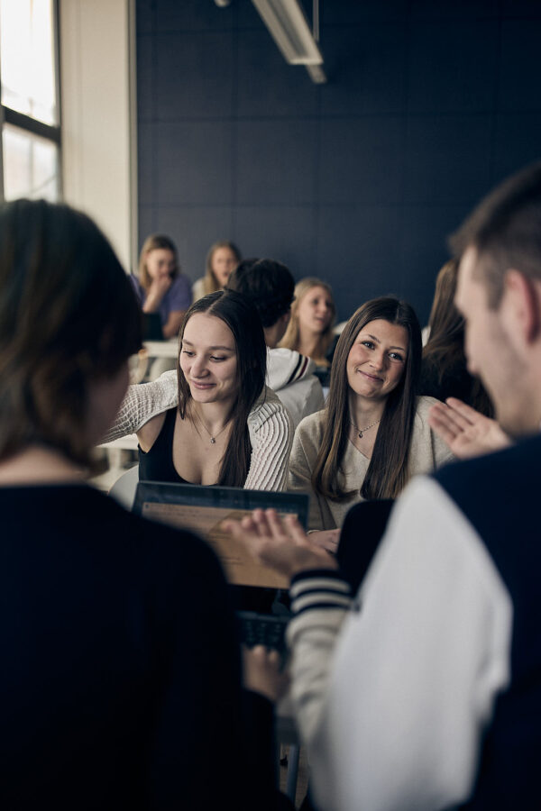 Elever vid Varbergs Enskilda Gymnasieskola samarbetar i grupp kring uppgift i klassrumsmiljö.